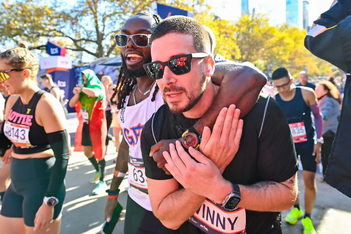 Man with his arm around Vinny Guadagnino at NYC marathon finish line