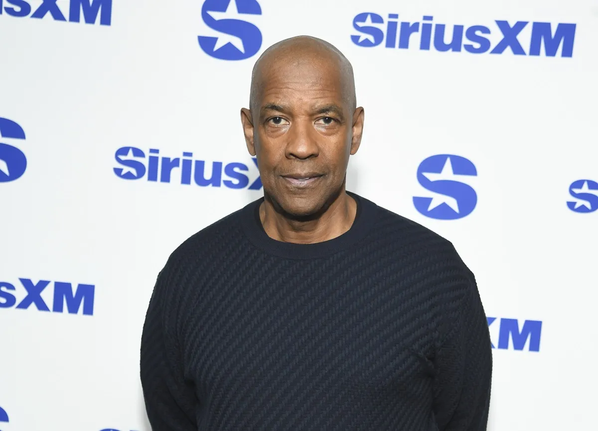 Denzel Washington posing at the Sirius XM townhall in a black shirt.