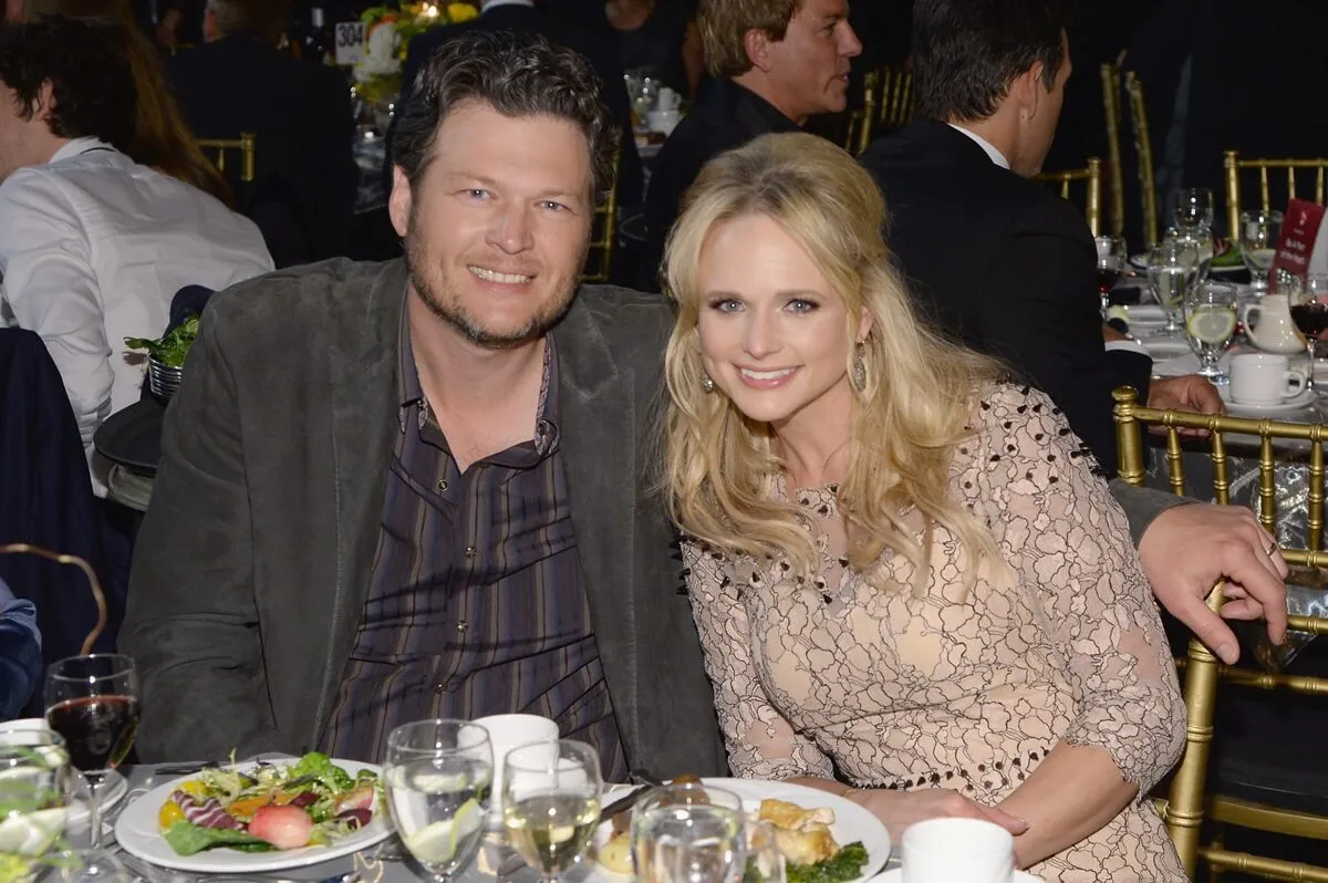 Blake Shelton sitting next to Miranda Lambert while they have dinner.