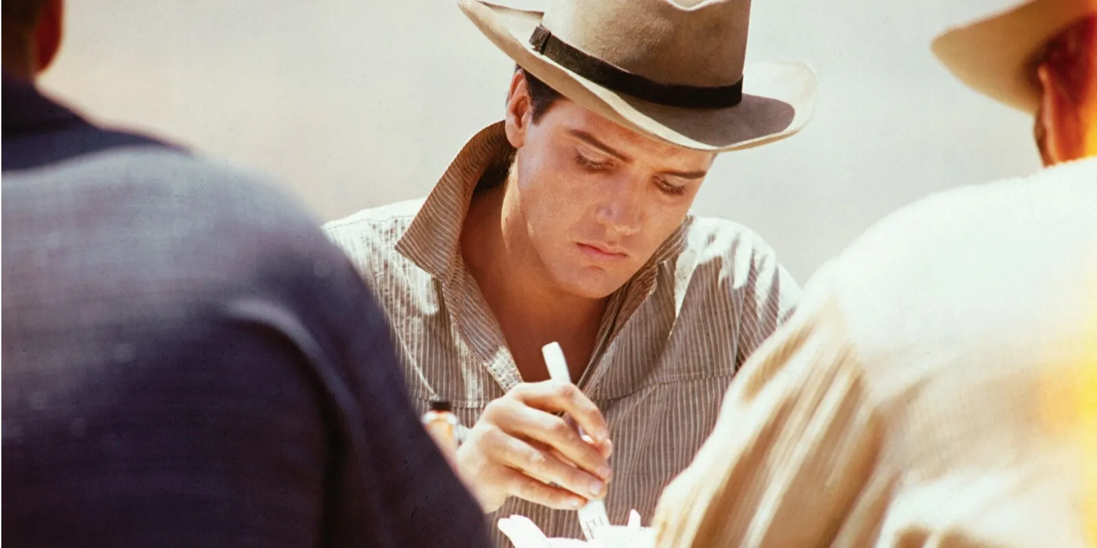 Elvis Presley eating on the set of the film 'Flaming Star' in 1960.