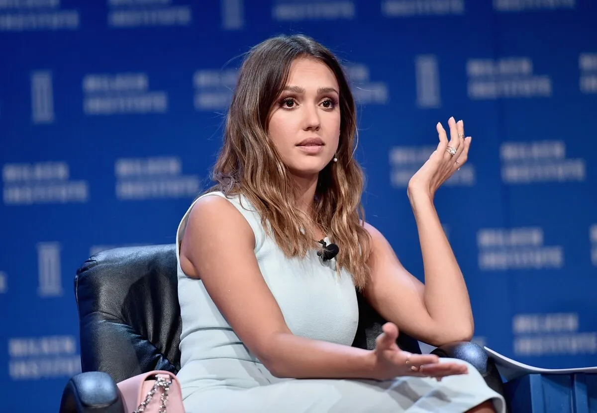 Jessica Alba speaks onstage during 2016 Milken Institute Global Conference while wearing a blue dress.