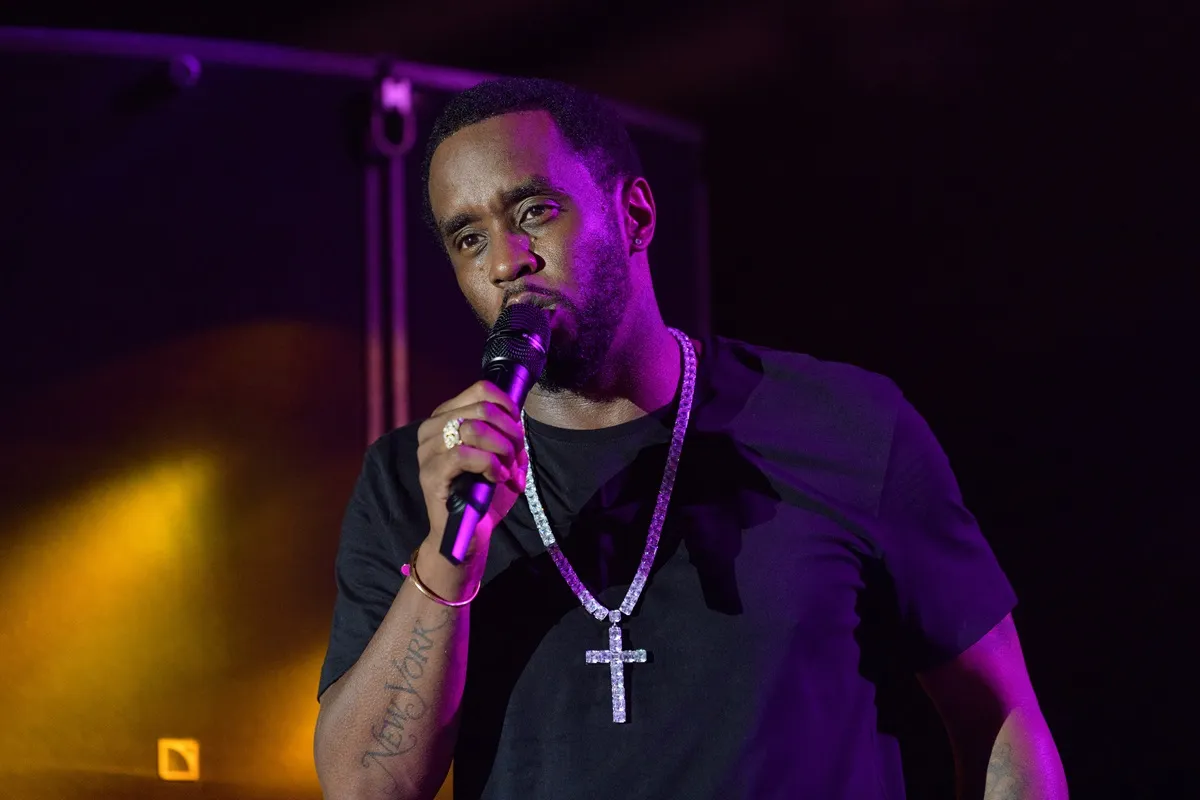 Sean Diddy Combs performing on stage while wearing a black t-shirt.