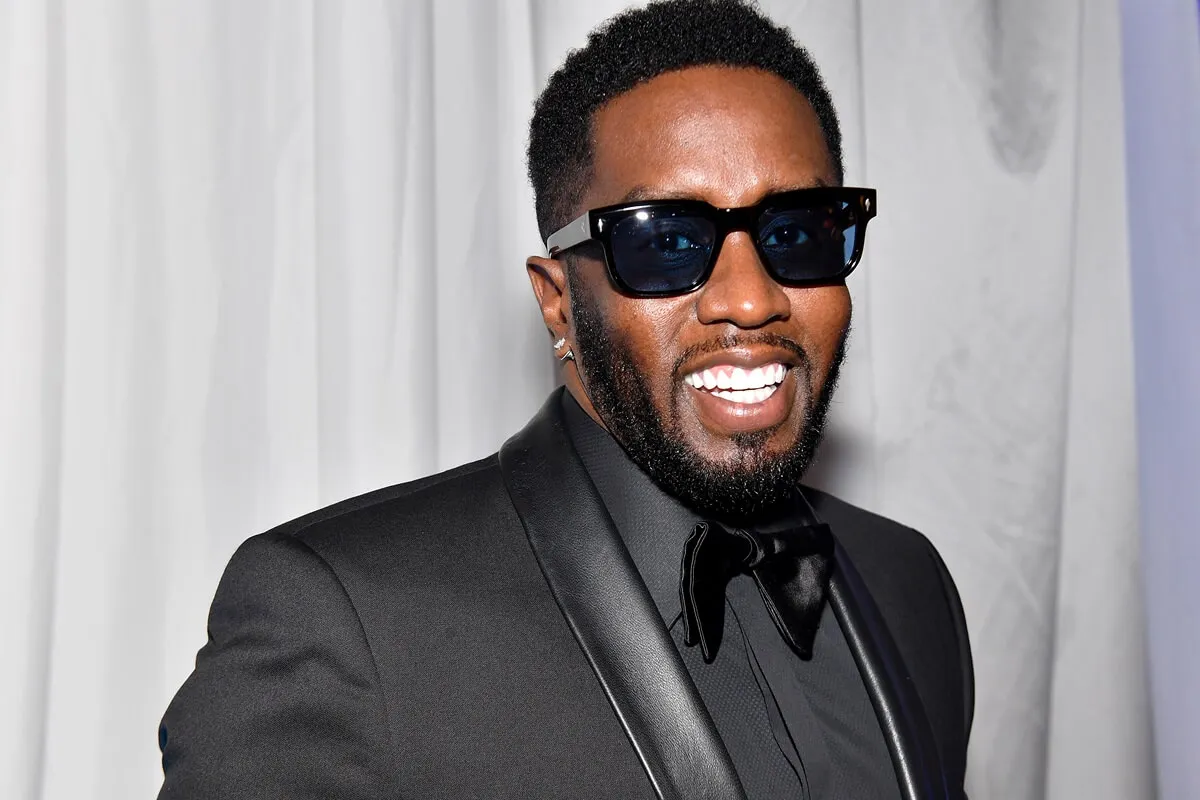 A close-up of Sean 'Diddy' Combs smiling in a black suit