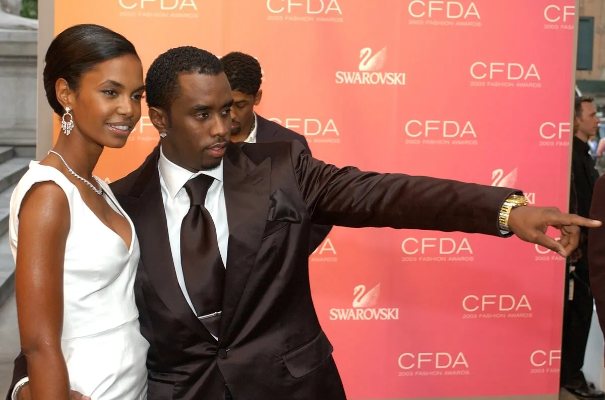 Kim Porter and Sean Diddy Combs at the 2003 CFDA Fashion Awards while wearing a white dress and suit respectively.