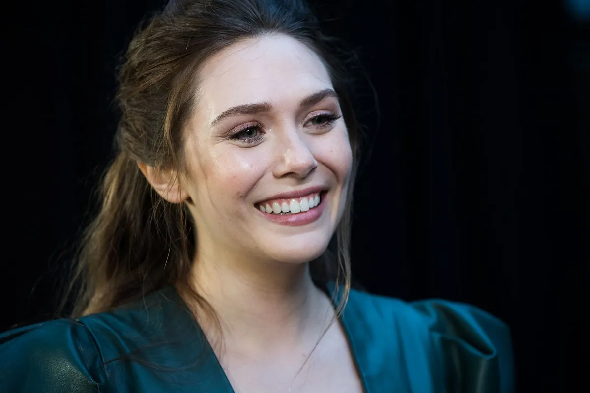 Elizabeth Olsen posing at the UK Fan Event to celebrate the release of Marvel Studios' 'Avengers: Infinity War' in a green dress.