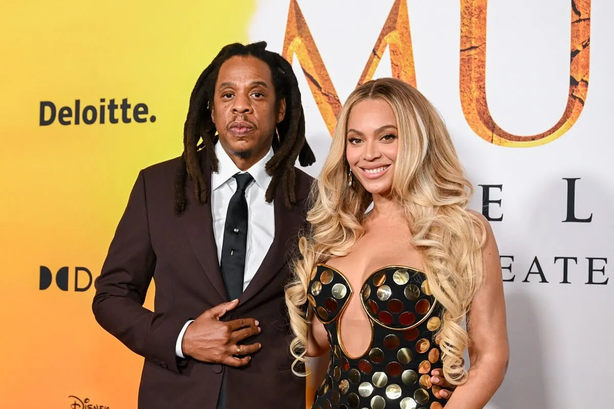 Jay-Z posing in a suit alongside Beyonce who's wearing a dress at the premiere of 'Mufasa'.