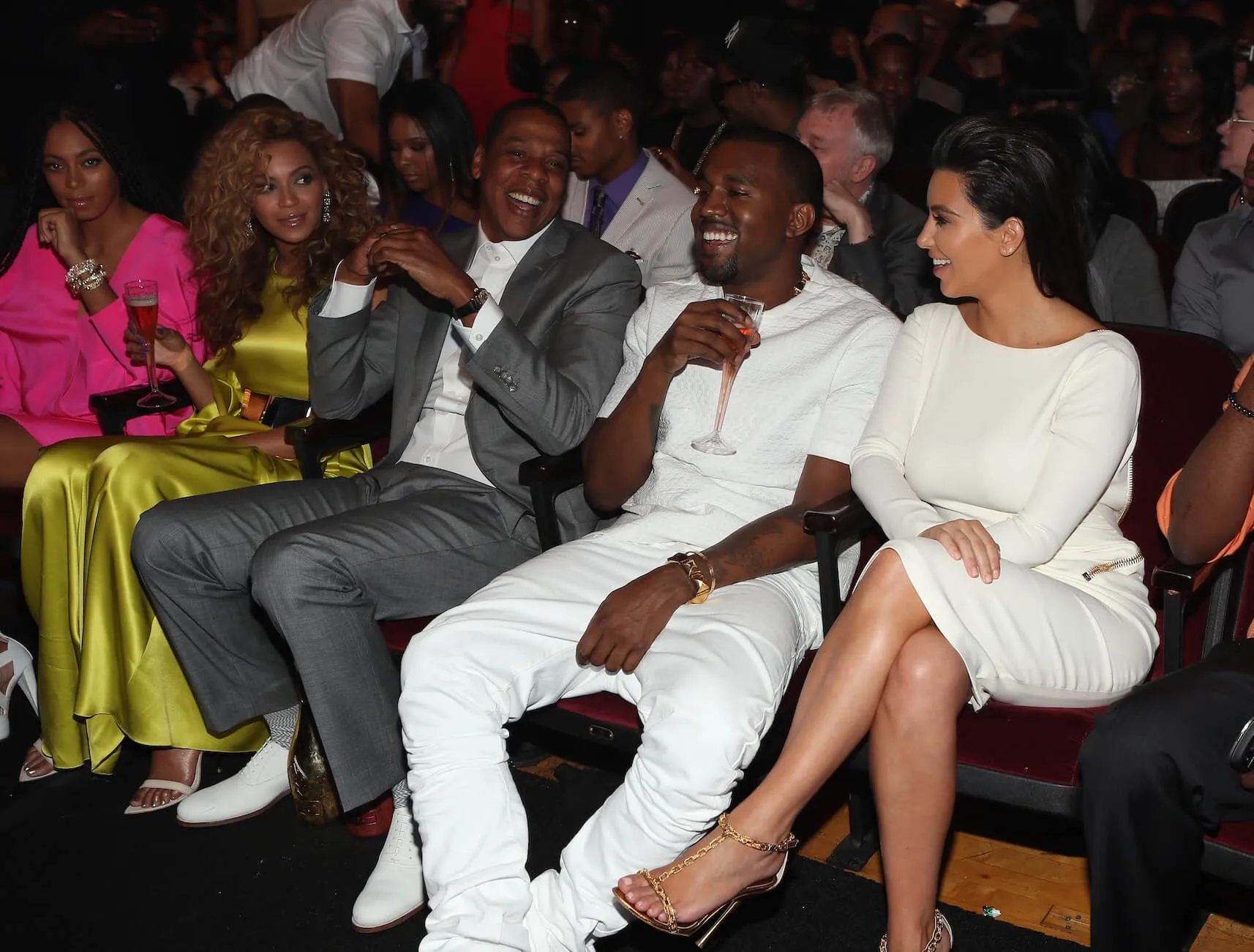 Beyoncé, Jay-Z, Kanye West, and Kim Kardashian sitting next to each other and laughing in 2012