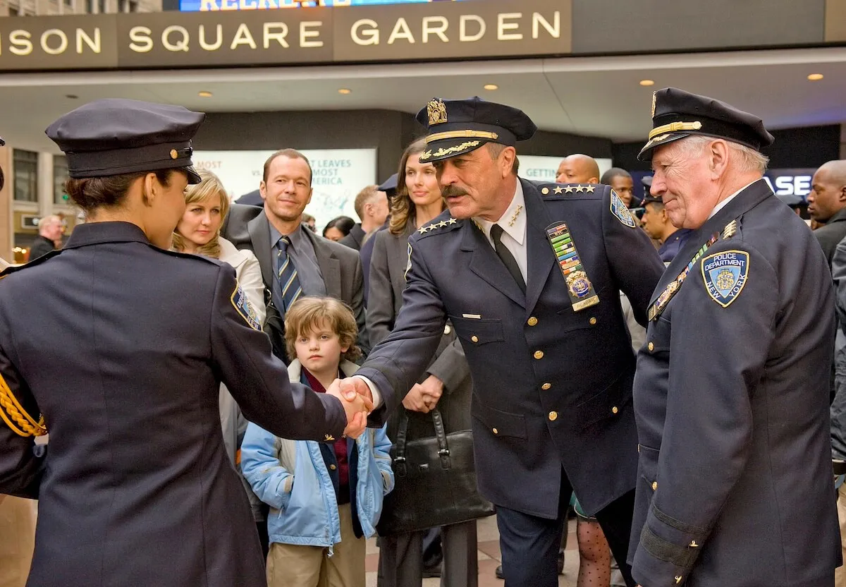 Tom Selleck, in a police uniform, shakes a man's hand outside of Madison Square Garden in the 'Blue Bloods' series premiere