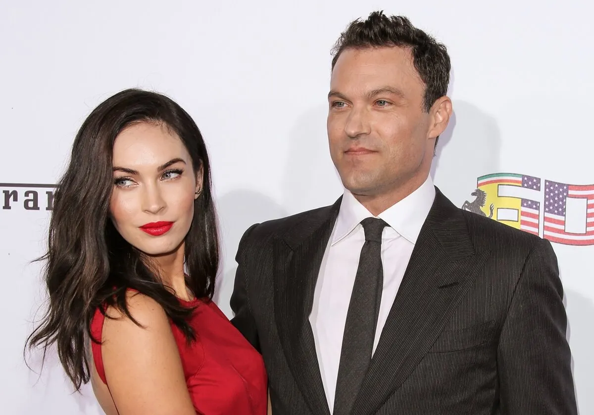 Megan Fox and Brian Austin Green posing at Ferrari's 60th Anniversary In The USA Gala in a red dress and suit respectively.