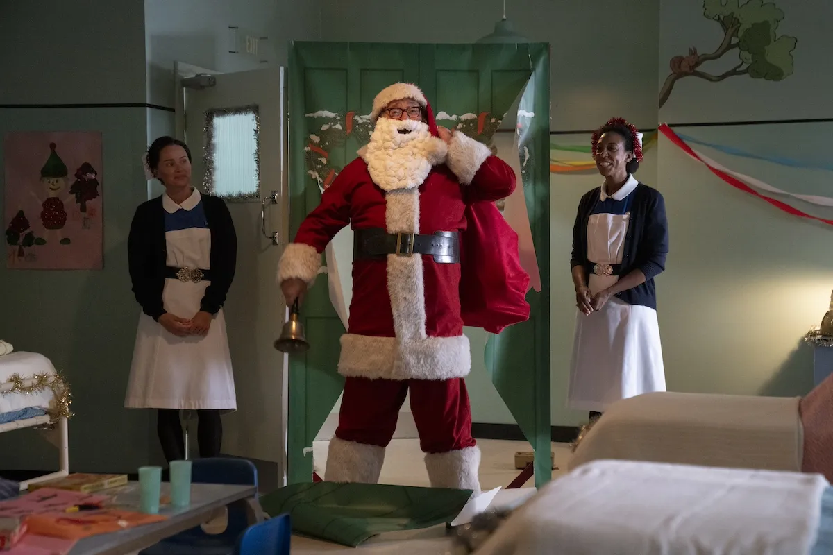 Man dressed in a Santa costume with two nurses standing on either side in the 2024 'Call the Midwife' Christmas special