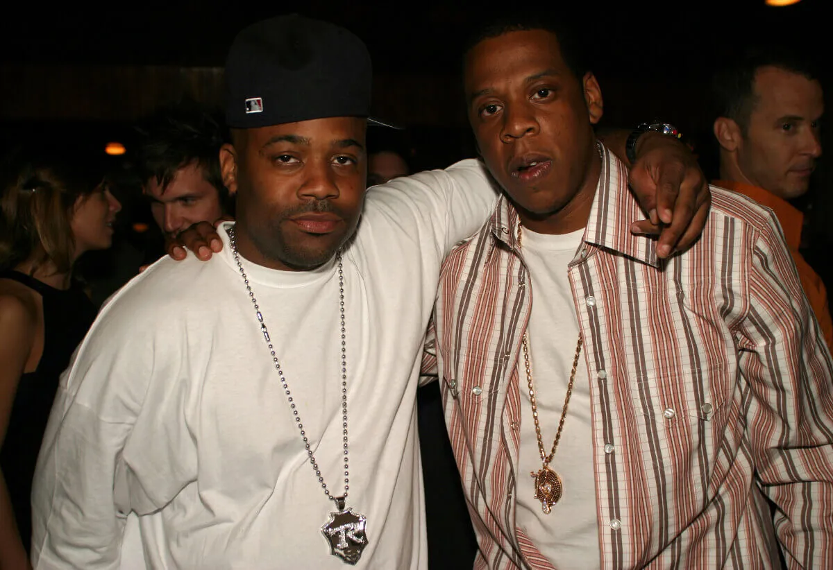 Damon Dash and Jay-Z stand with their arms around each other.