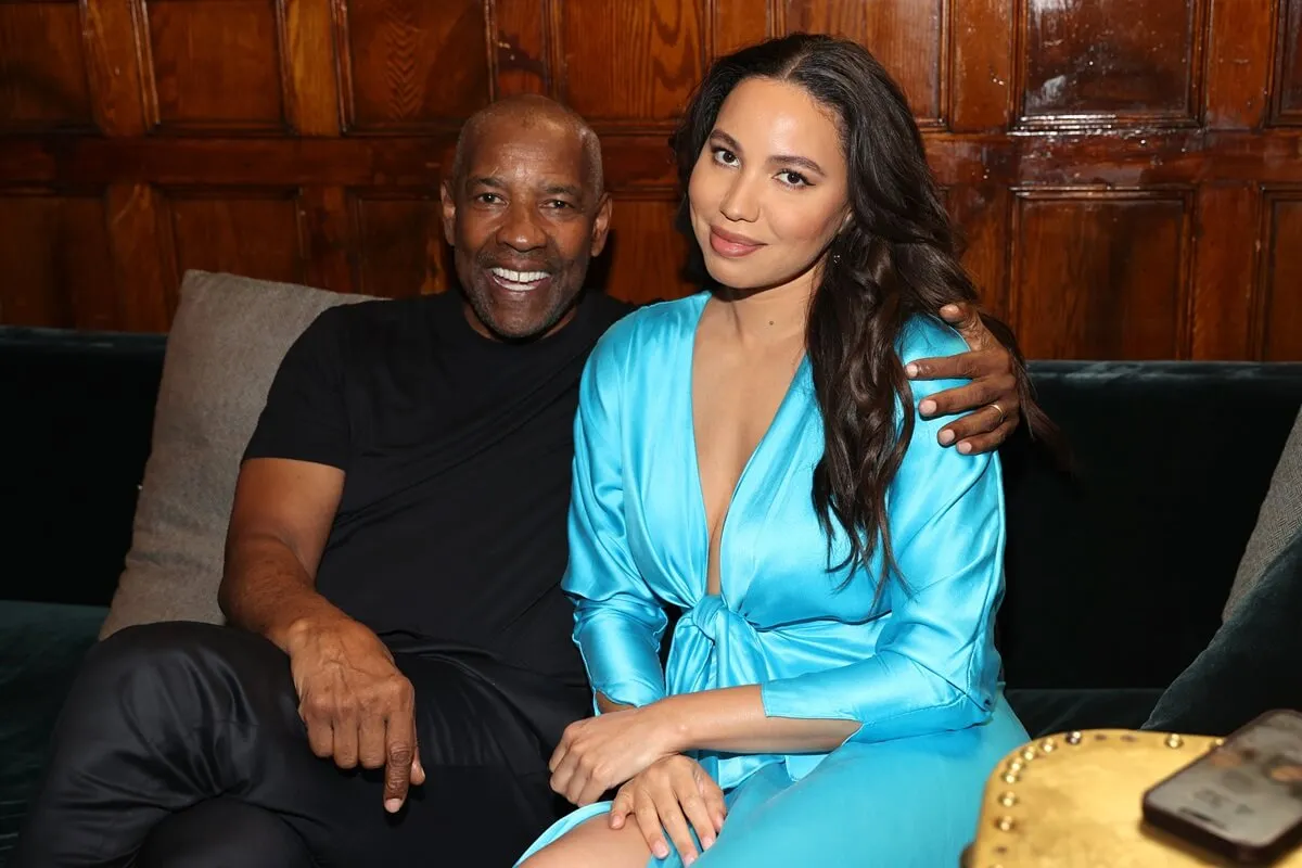 Denzel Washington sitting down smiling next to Jurnee Smollett at Netflix's special presentation of "The Piano Lesson".