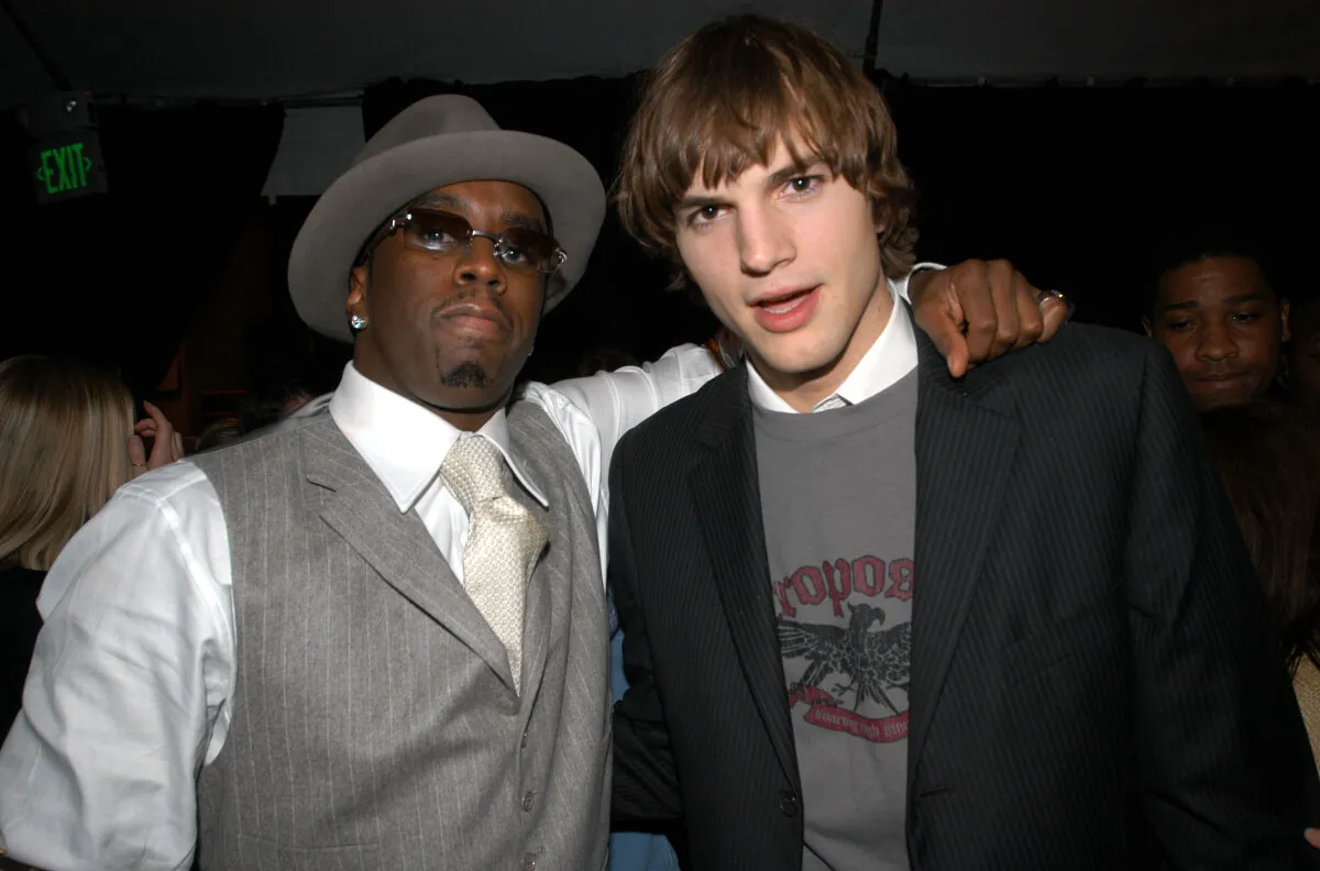 Sean 'Diddy' Combs stands with his arm around Ashton Kutcher's shoulders.