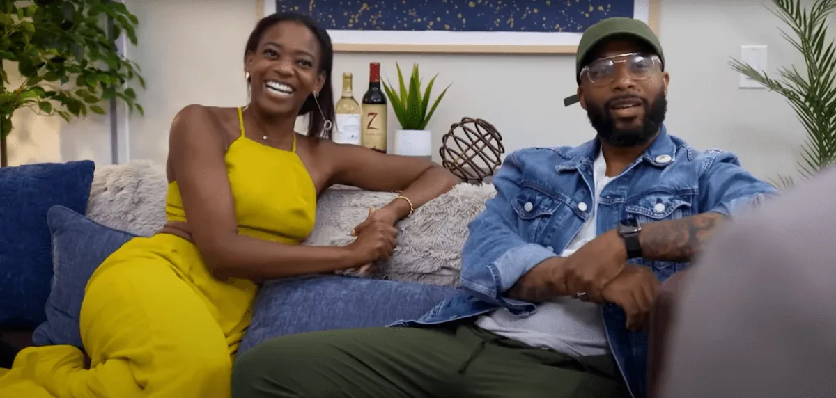 Smiling Emen and Ikechi sitting on a couch in 'Married at First Sight' Season 18