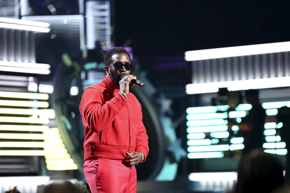 Sean Diddy Combs rapping on stage at the 2022 Billboard Music Awards in a red outfit.