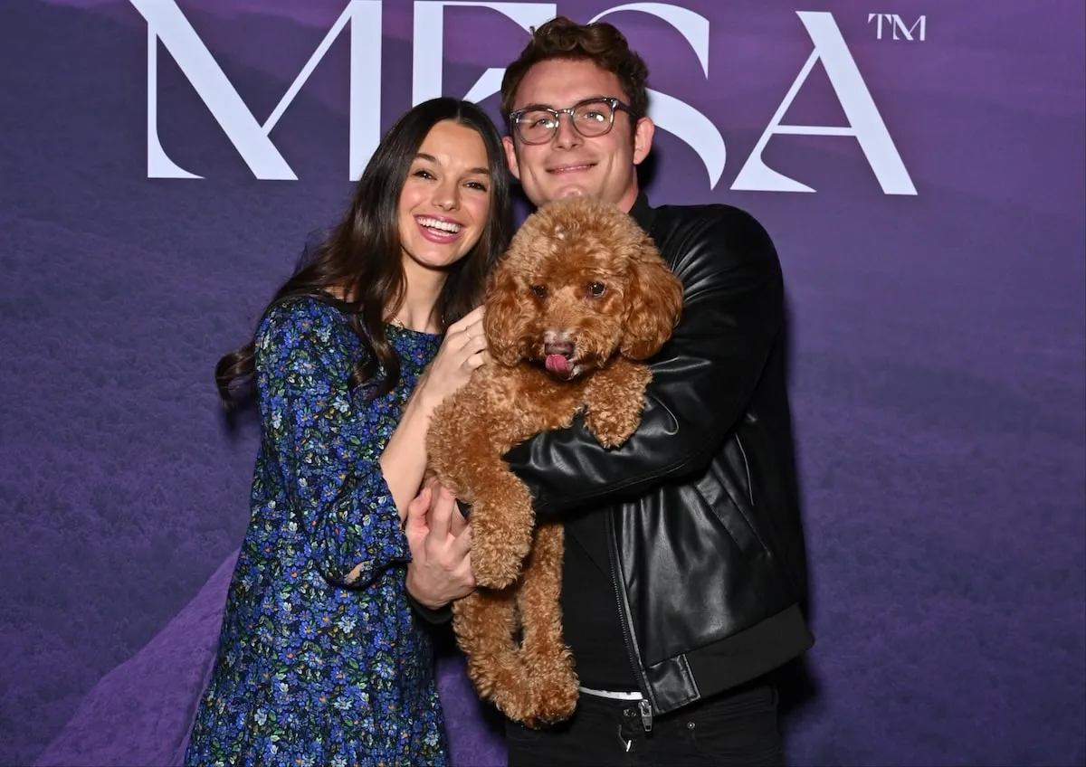 Smiling together, Ally Lewber and James Kennedy take photos with their goldendoodle Hippie at Dogsgiving with REÁL MESA