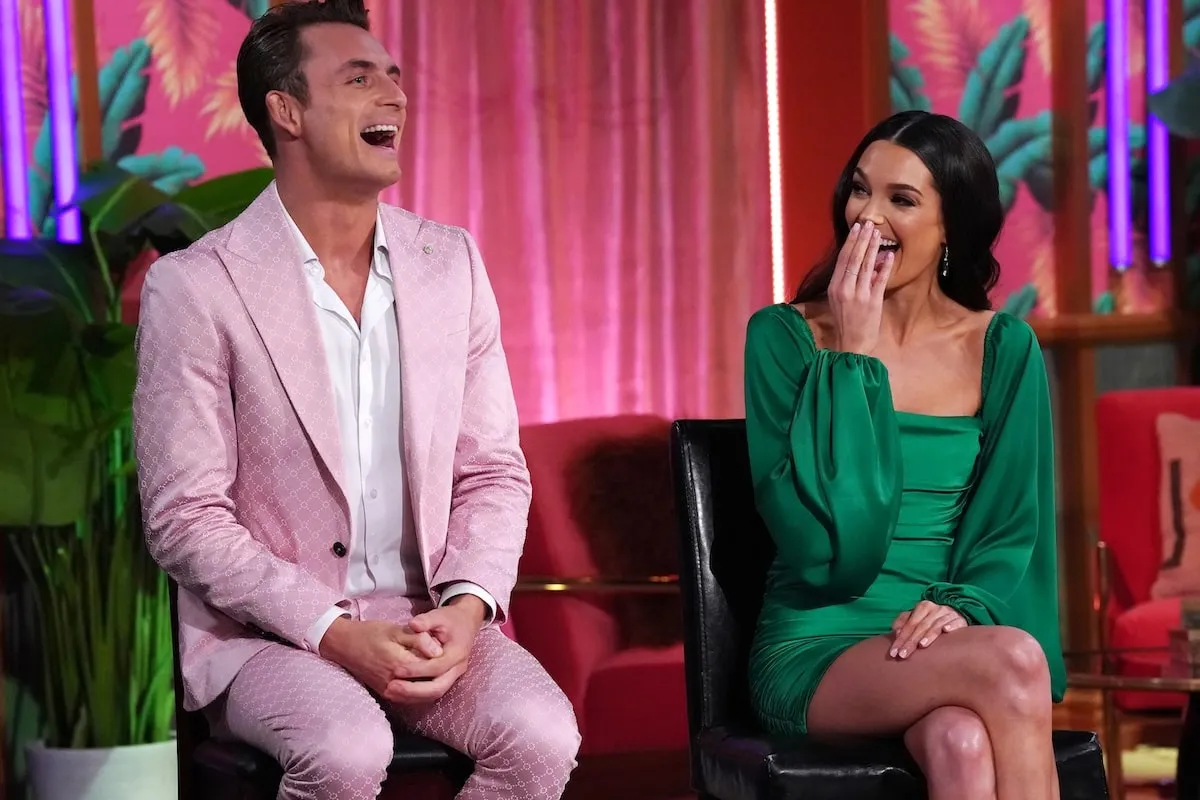 Wearing a pink suit and green dress respectively, James Kennedy and Ally Lewber laugh while filming the season 11 reunion episode for 'Vanderpump Rules'