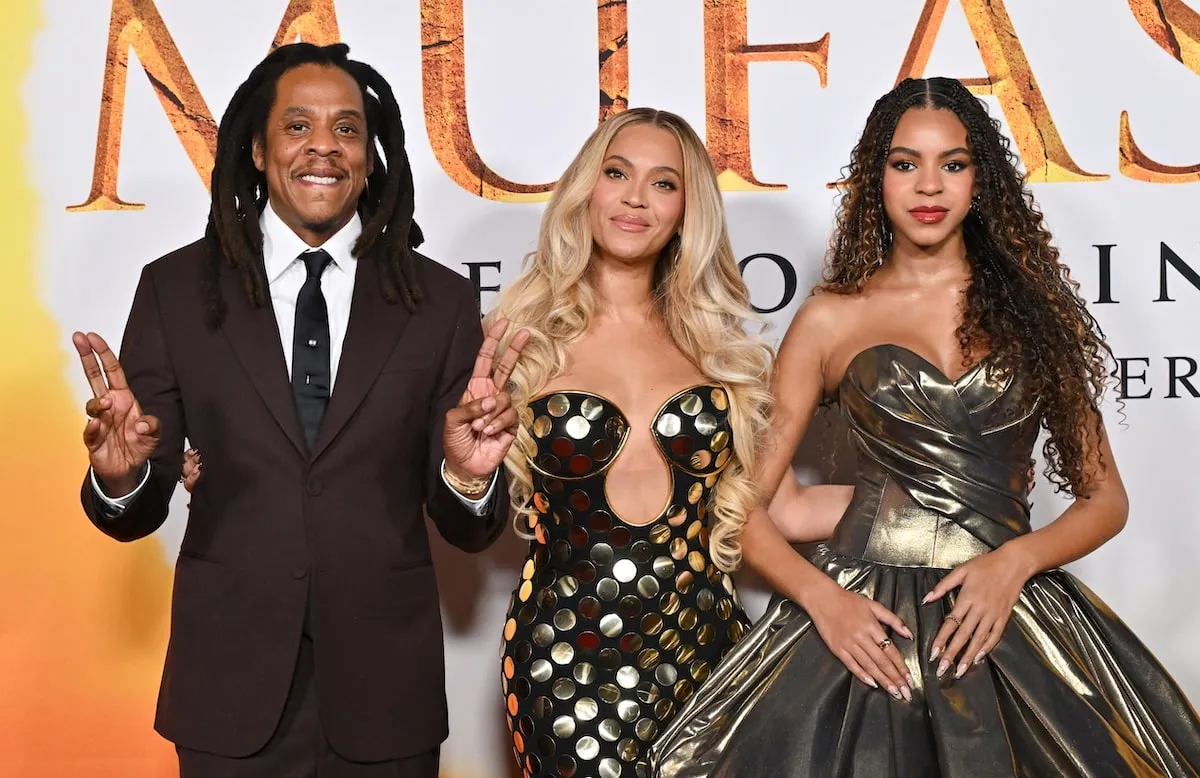 Wearing a gold dress, Blue Ivy smiles with her mom Beyoncé and dad Jay-Z on the red carpet at the 'Mufasa' premiere