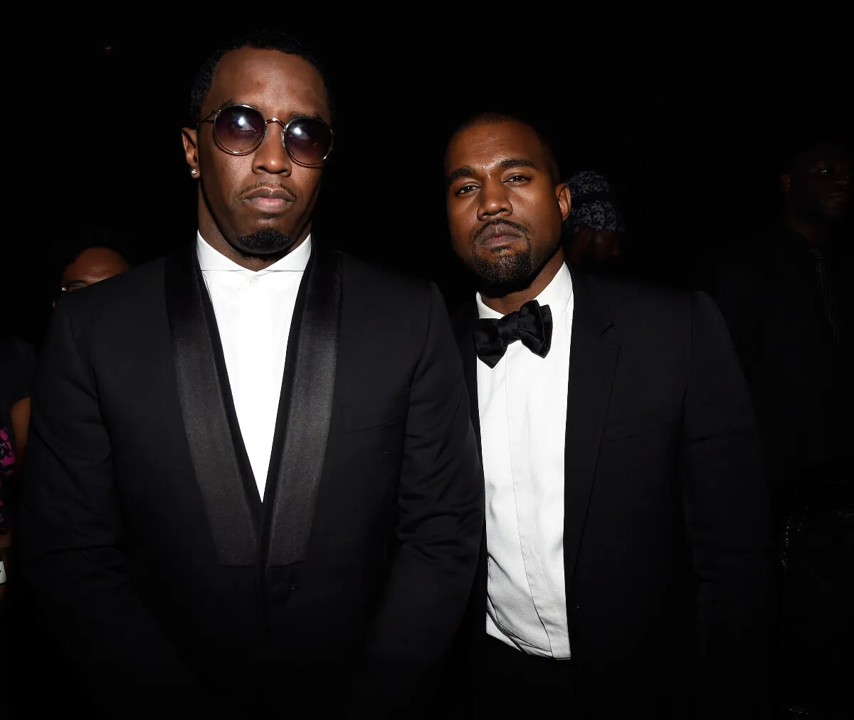 Sean 'Diddy' Combs and Kanye West stand together. Diddy wears sunglasses.