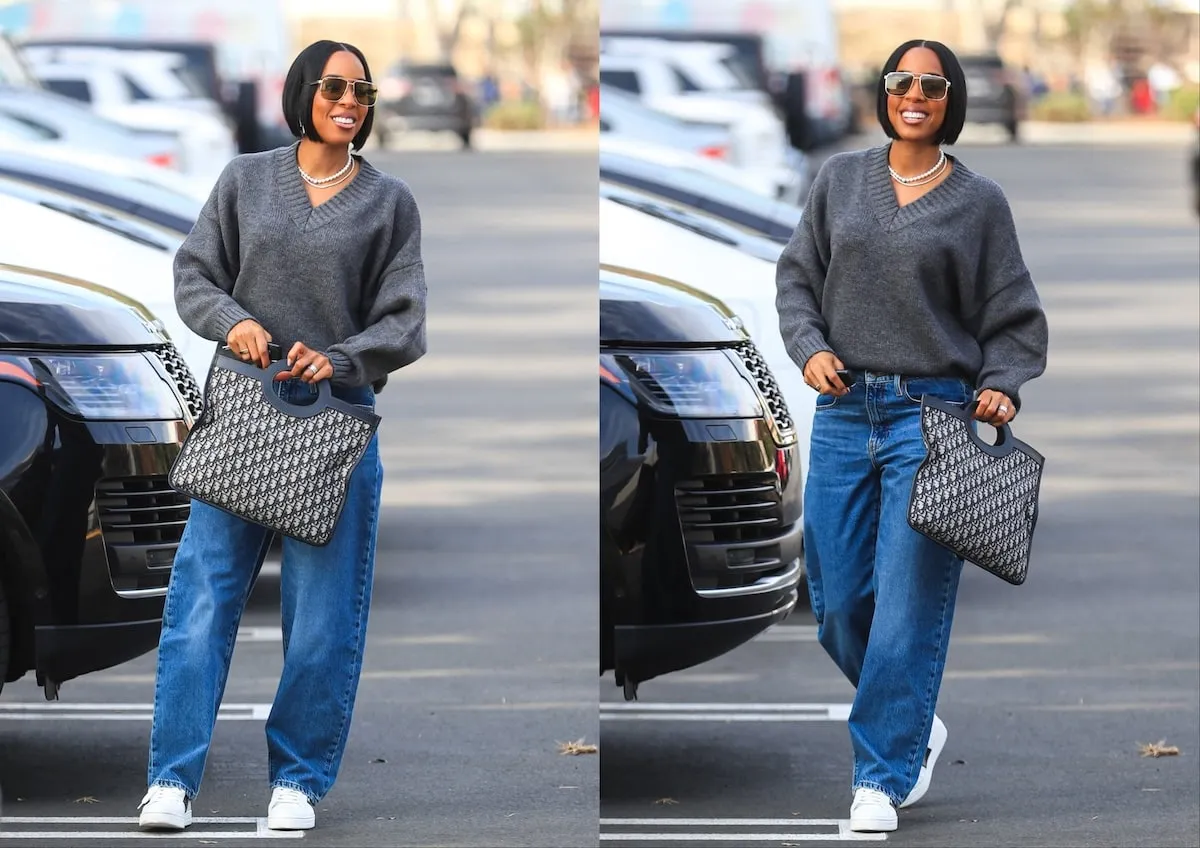 Wearing a gray sweater and baggy jeans, Kelly Rowland walks through the parking lot at LA's BMO Stadium