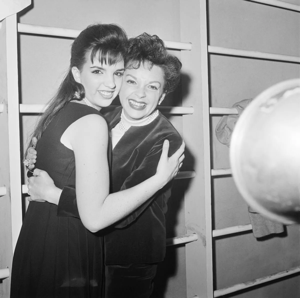 A black and white picture of Liza Minnelli and Judy Garland embracing each other.