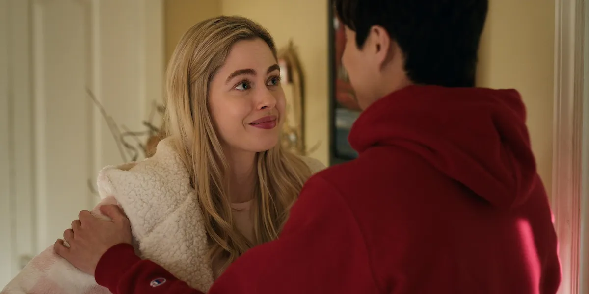 Smiling blonde-haired woman looking at a man in a red sweatshirt