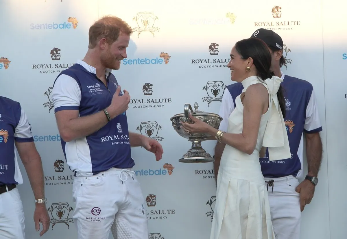 Meghan Markle presents a trophy to Prince Harry after his Royal Salute Sentebale Team defeated the Grand Champions Team