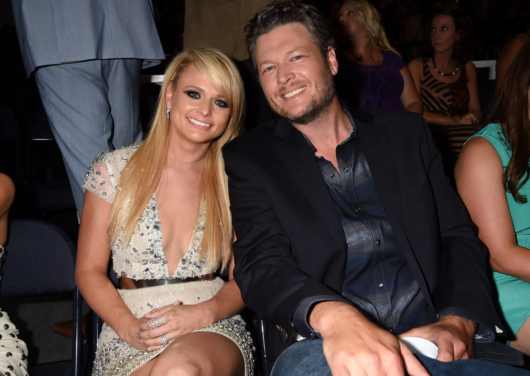 Miranda Lambert and Blake Shelton sitting next to each other and smiling at the CMT Music Awards in 2014