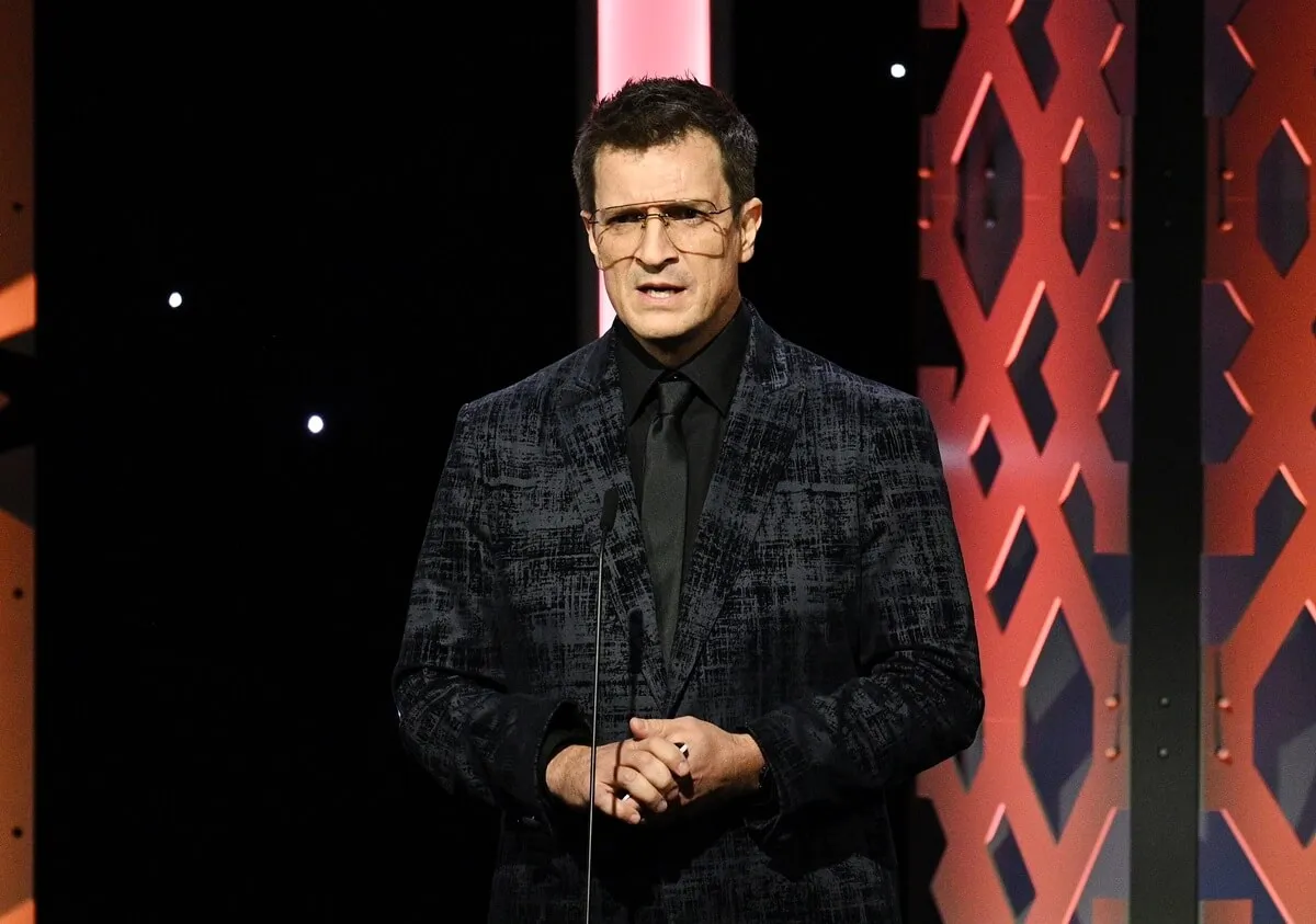 Nathan Fillion posing at 36th Annual American Cinematheque Awards in a black suit.