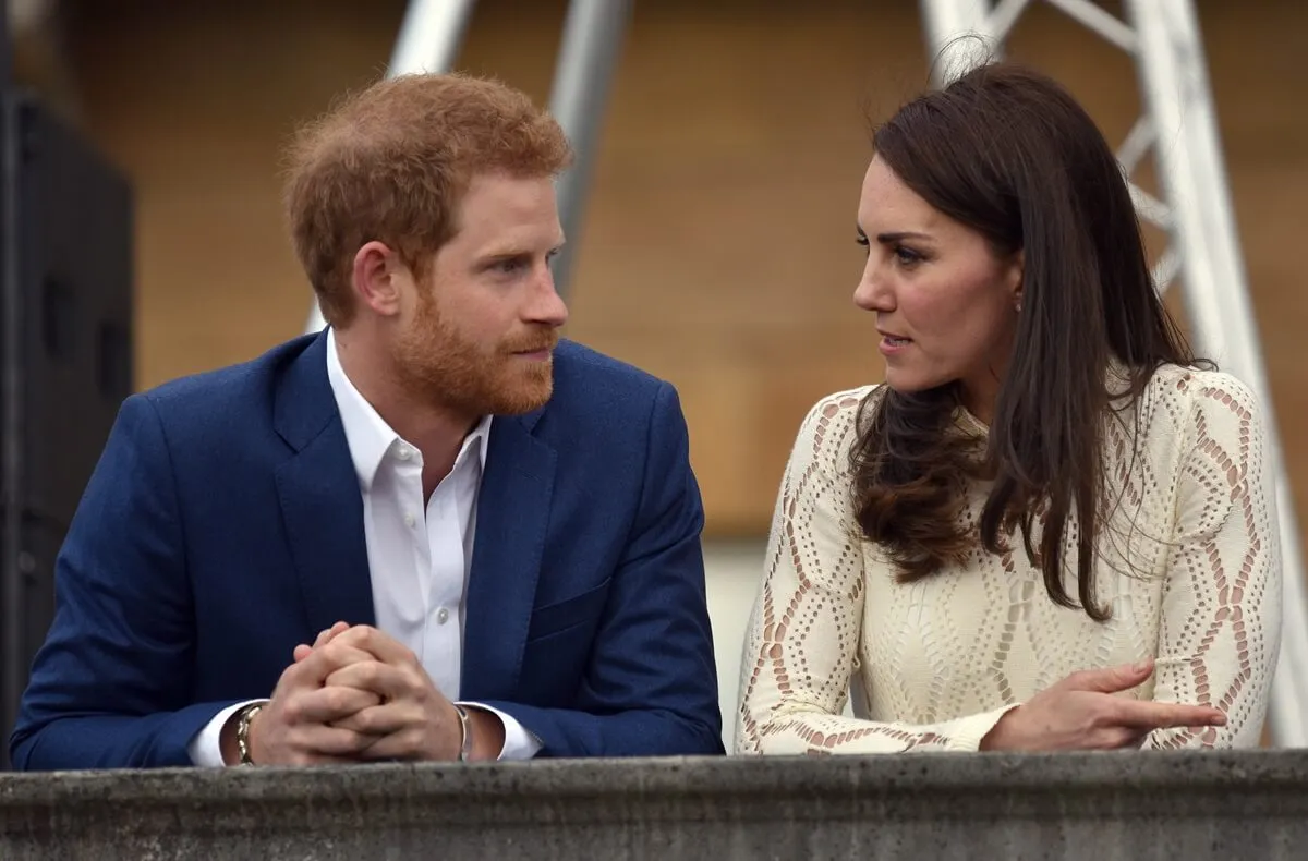 Prince Harry and Kate Middleton speak during a tea party on the grounds of Buckingham Palace