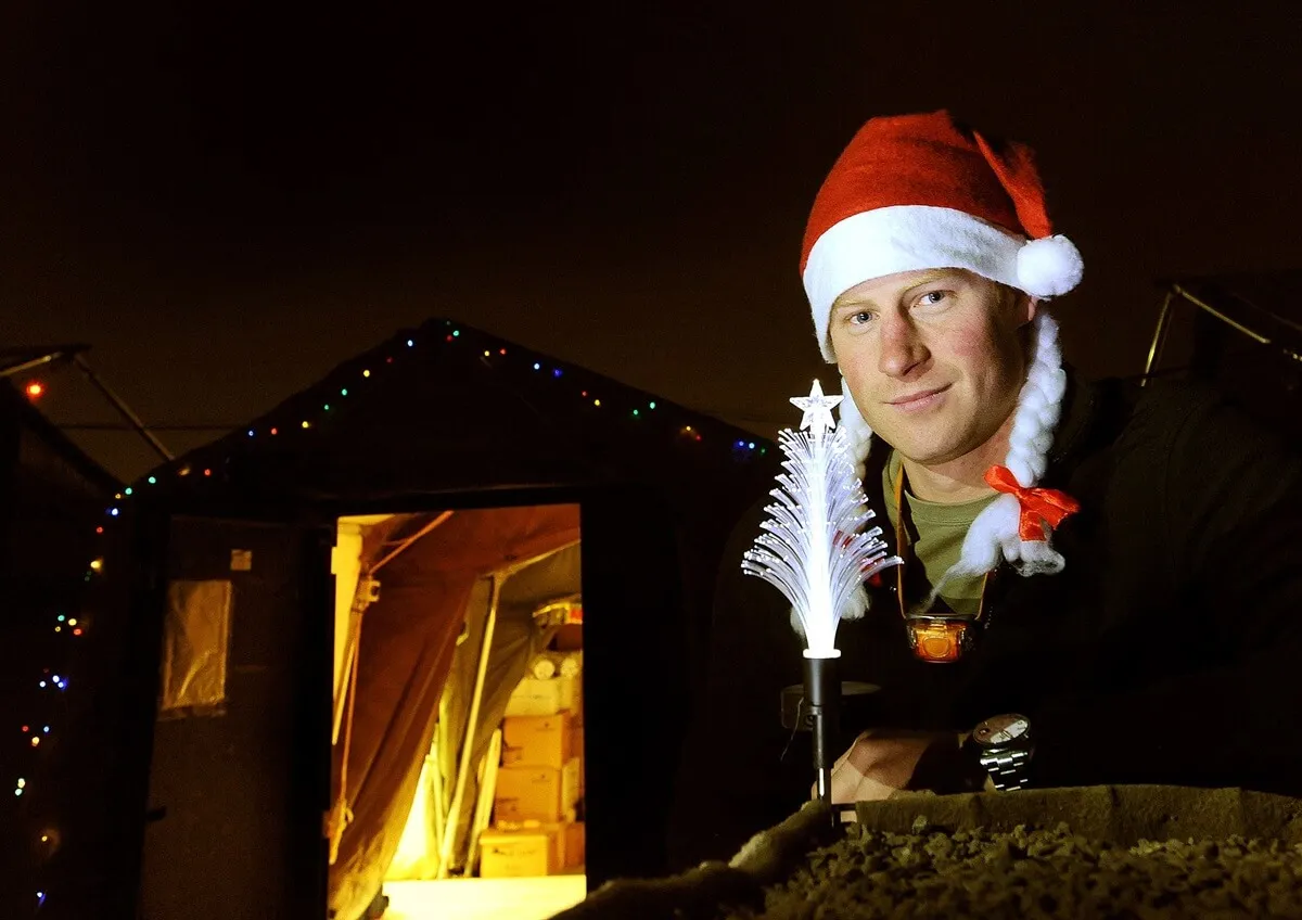 Prince Harry wearing a Christmas hat outside a tent at Camp Bastion in Afghanistan