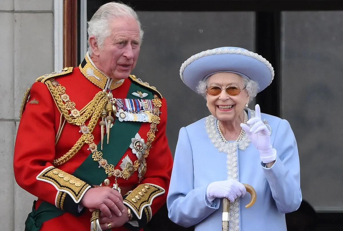 Queen Elizabeth II stands next to then-Prince Charles to watch a flypast from the Buckingham Palace balcony