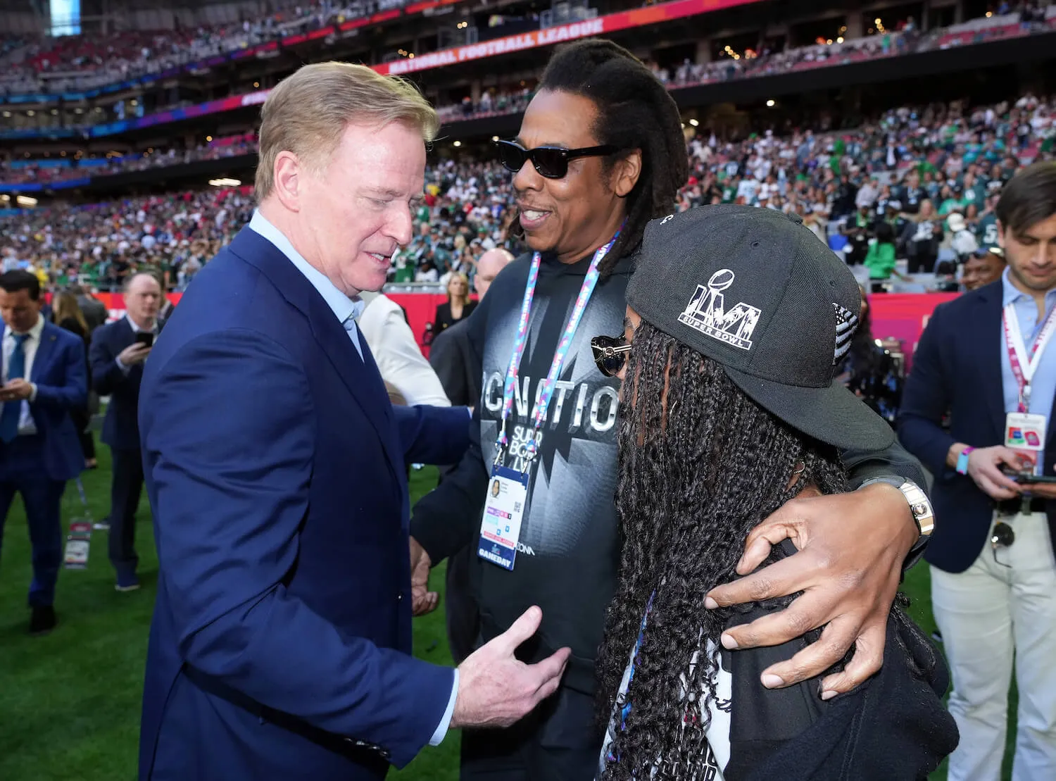 Roger Goodell, Jay-Z, and Blue Ivy Carter attend Super Bowl LVII at State Farm Stadium on Feb. 12, 2023. Goodell is turned toward Blue Ivy and talking to her on the field.