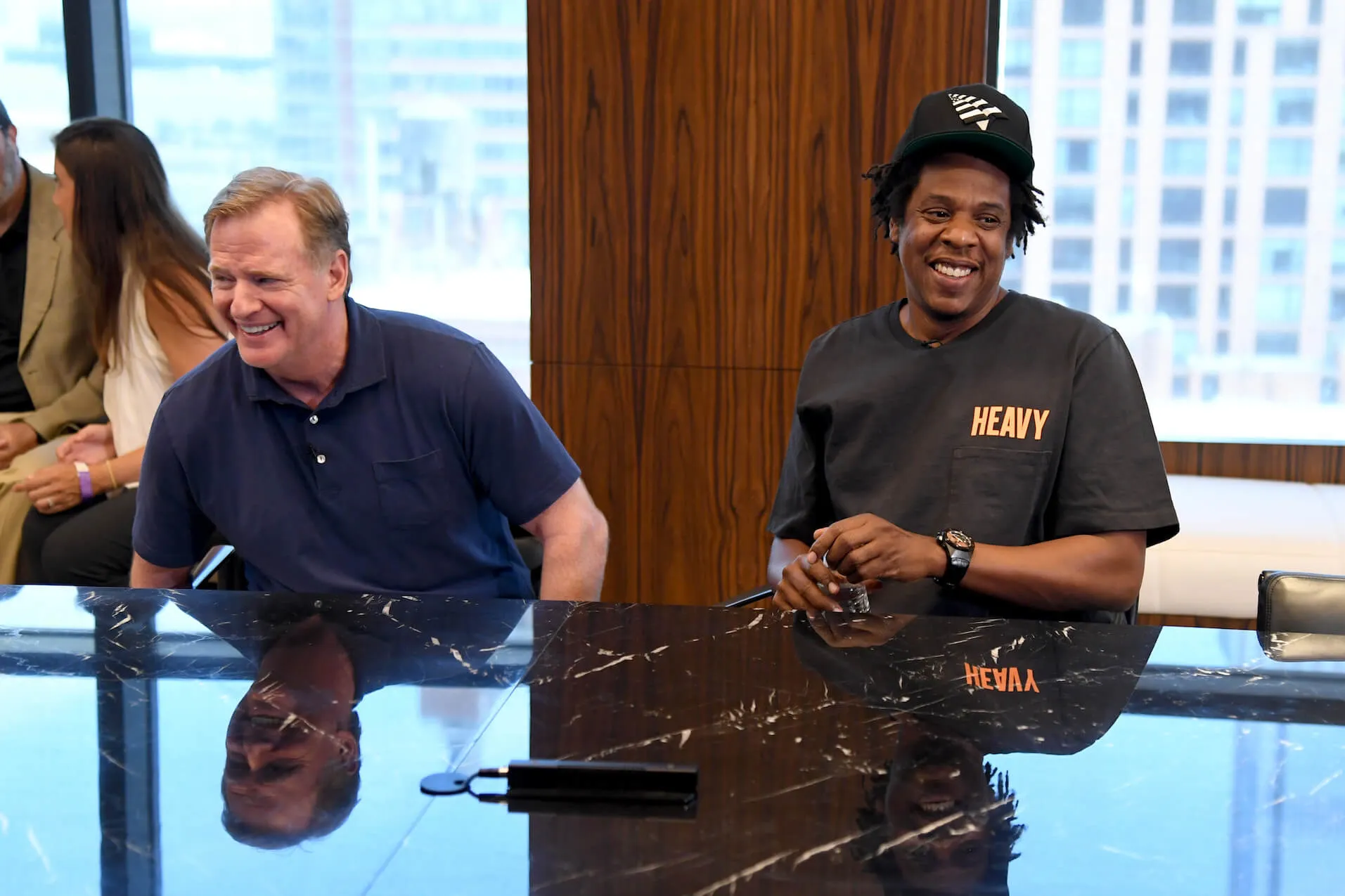 NFL Commissioner Roger Goodell and Jay-Z laughing while sitting at a desk together in 2019