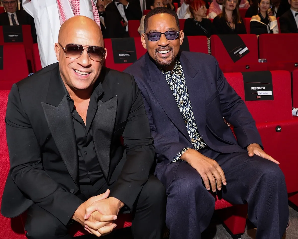 Wearing a navy suit, Will Smith sits next to Vin Diesel at the Opening Ceremony at the Red Sea International Film Festival 2024