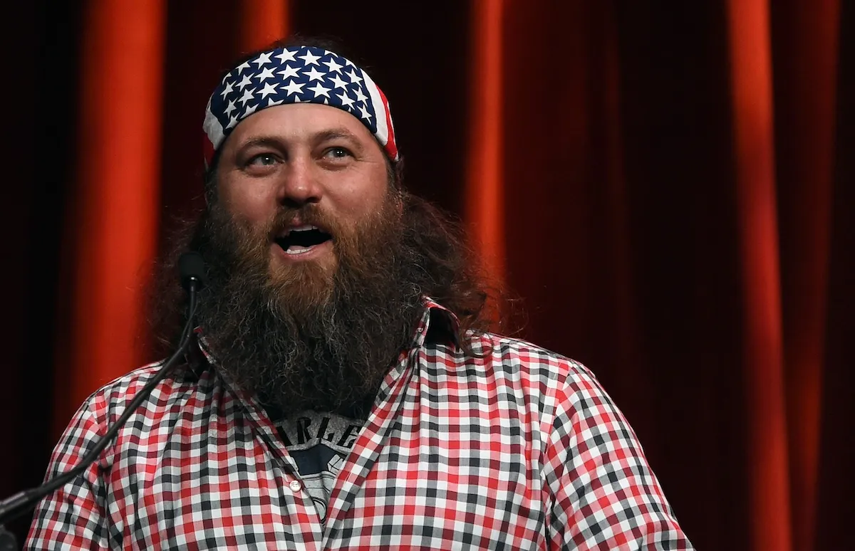 Duck Dynasty star Willie Robertson wearing a red, white and blue checked shirt and an American flag bandana