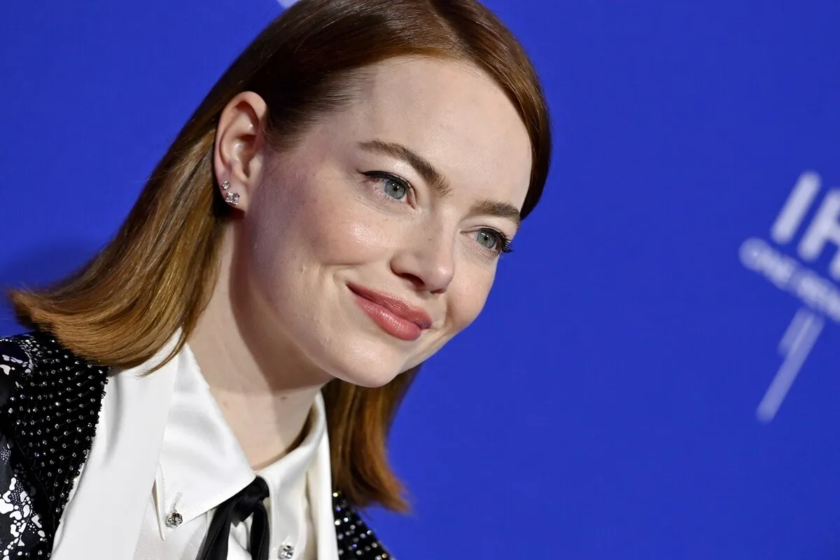 Emma Stone posing at the 2024 Palm Springs International Film Festival while wearing a suit.