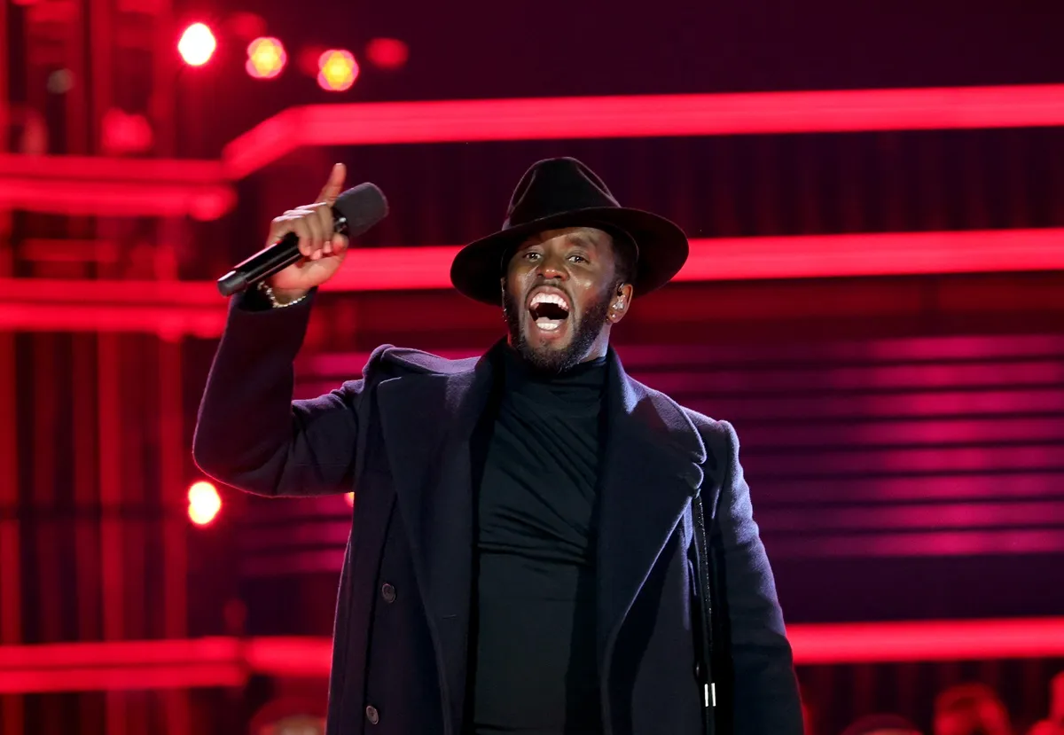 Sean Diddy Combs speaking on stage during the 2022 Billboard Music Awards in an all black outfit.