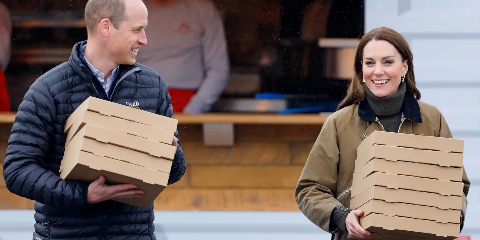 Prince William and Kate Middleton carry pizza boxes in 2023.