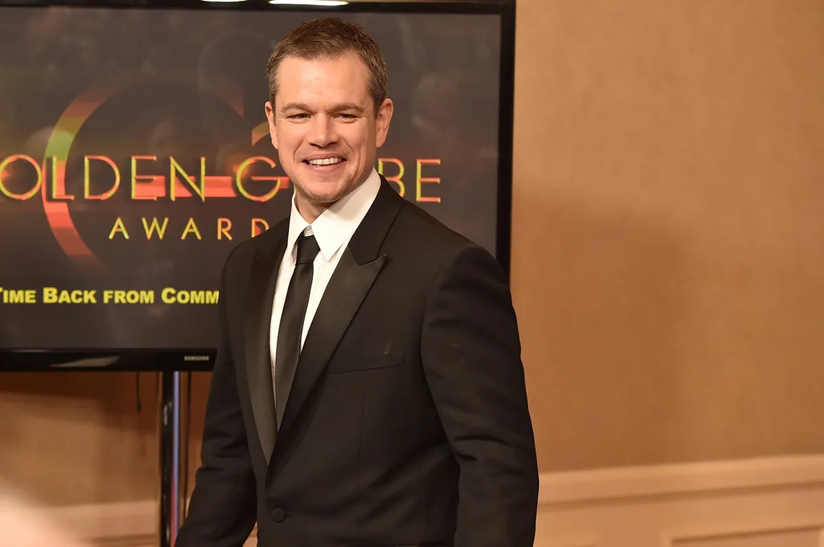 Matt Damon posing at the Golden Globes in a suit.