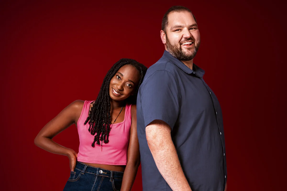 Joan leans against Gregory's back against a red background in a promo portrait for '90 Day Fiancé'