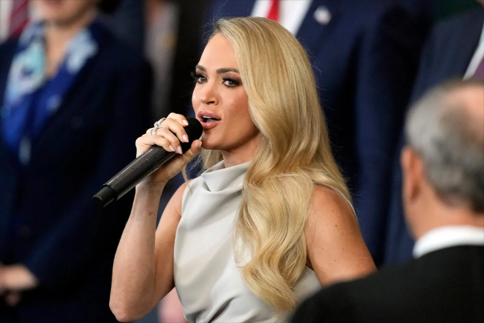 'American Idol' Season 23 judge Carrie Underwood holding a microphone up to her lips at the 2nd Inauguration of Donald Trump