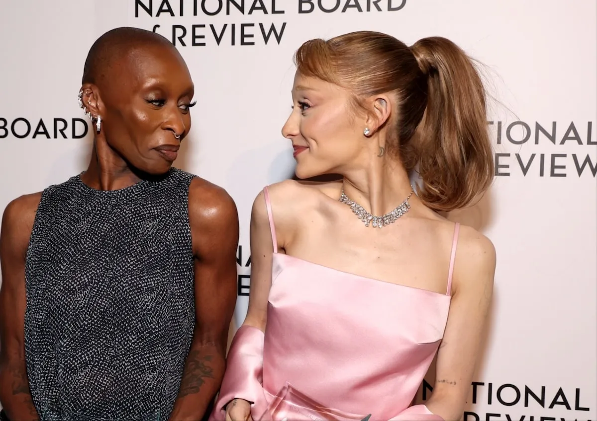 Wearing a black dress and pink dress respectively, Cynthia Erivo and Ariana Grande pose with the NBR Spotlight Award