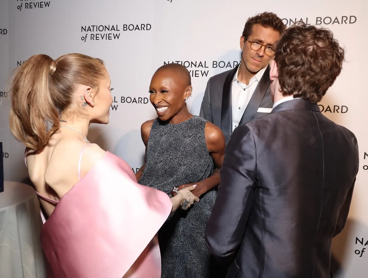 Smiling together on the red carpet, Ariana Grande, Cynthia Erivo, and Ethan Slater greet Ryan Reynolds