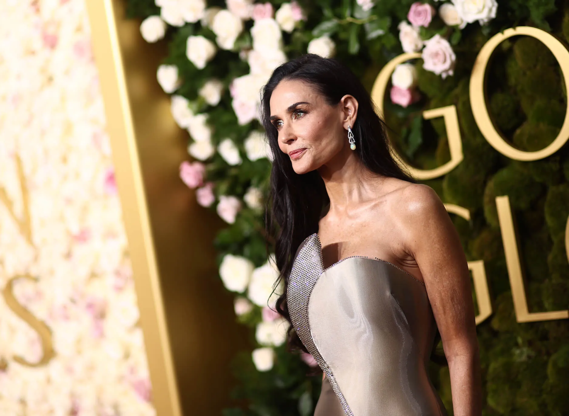 A side profile of Demi Moore posing for a photo at the Golden Globes in 2025. She's wearing a strapless gown.