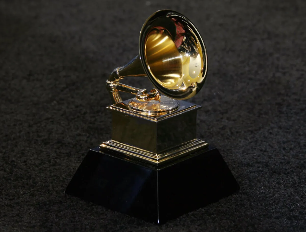 A Grammy statue sits on a gray floor.