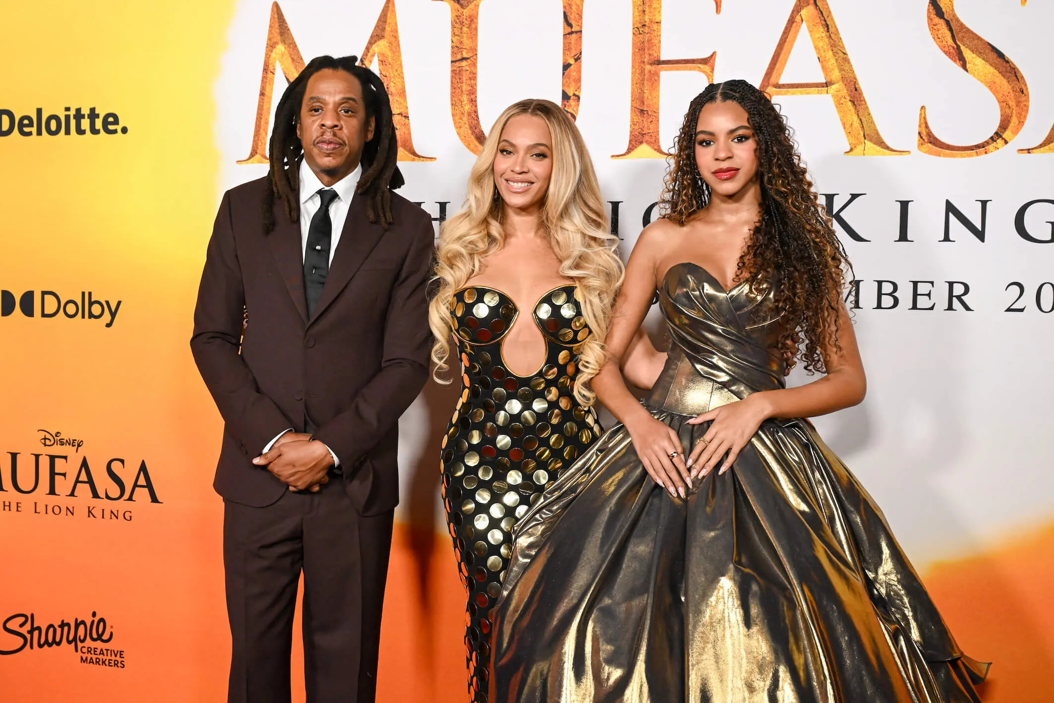 Jay-Z, Beyoncé, and Blue Ivy Carter at the 'Mufasa: The Lion King' premiere. They are standing next to each other for the cameras.