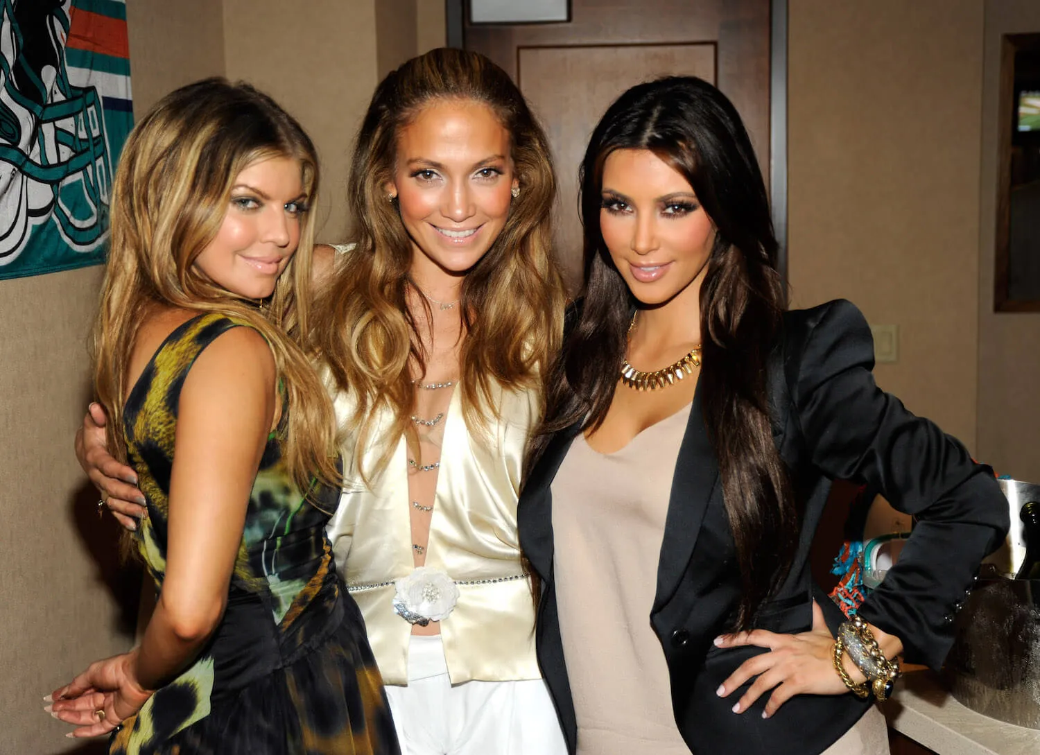 Fergie, Jennifer Lopez, and Kim Kardashian posing with their arms around each other in 2010