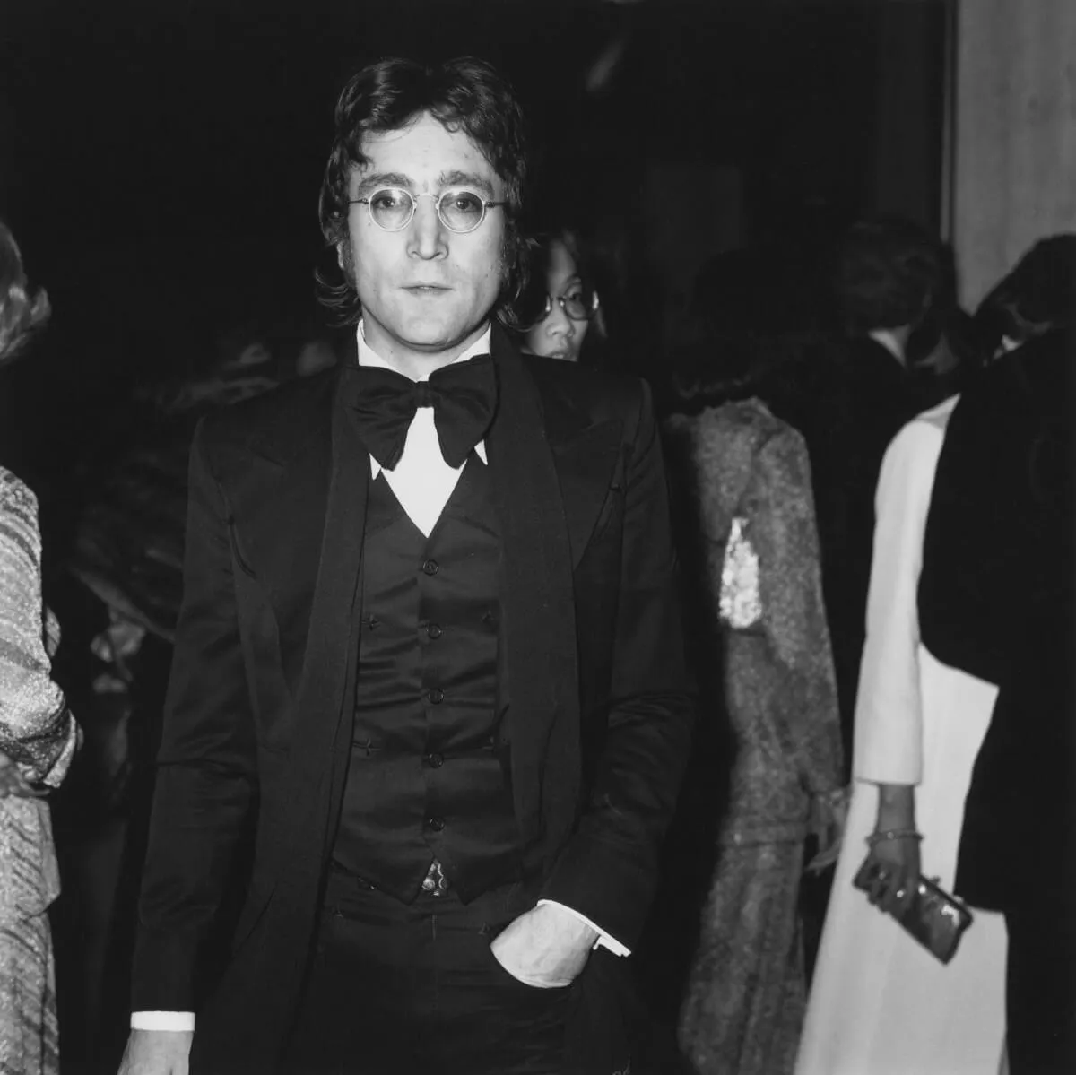 John Lennon wears a tuxedo and glasses.