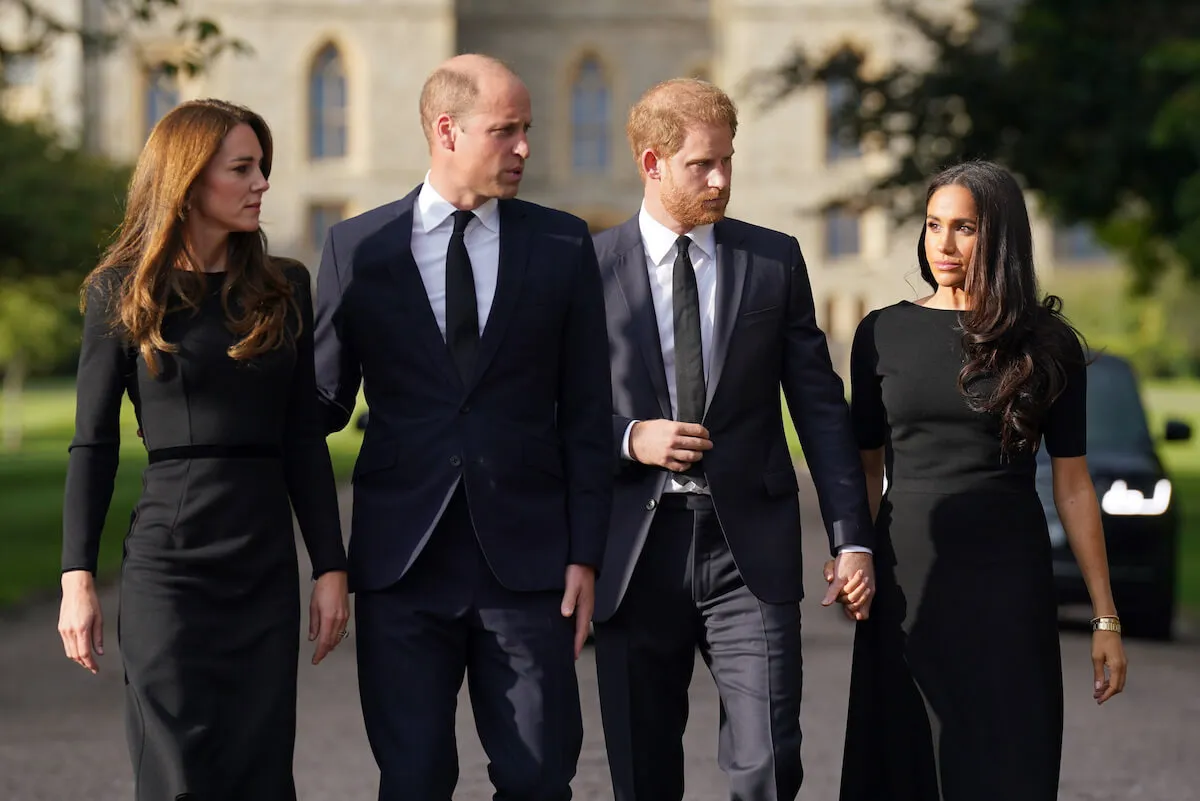 Kate Middleton and Prince William, who aren't 'in competition' with Prince Harry and Meghan Markle on social media, walk next to each other in 2022